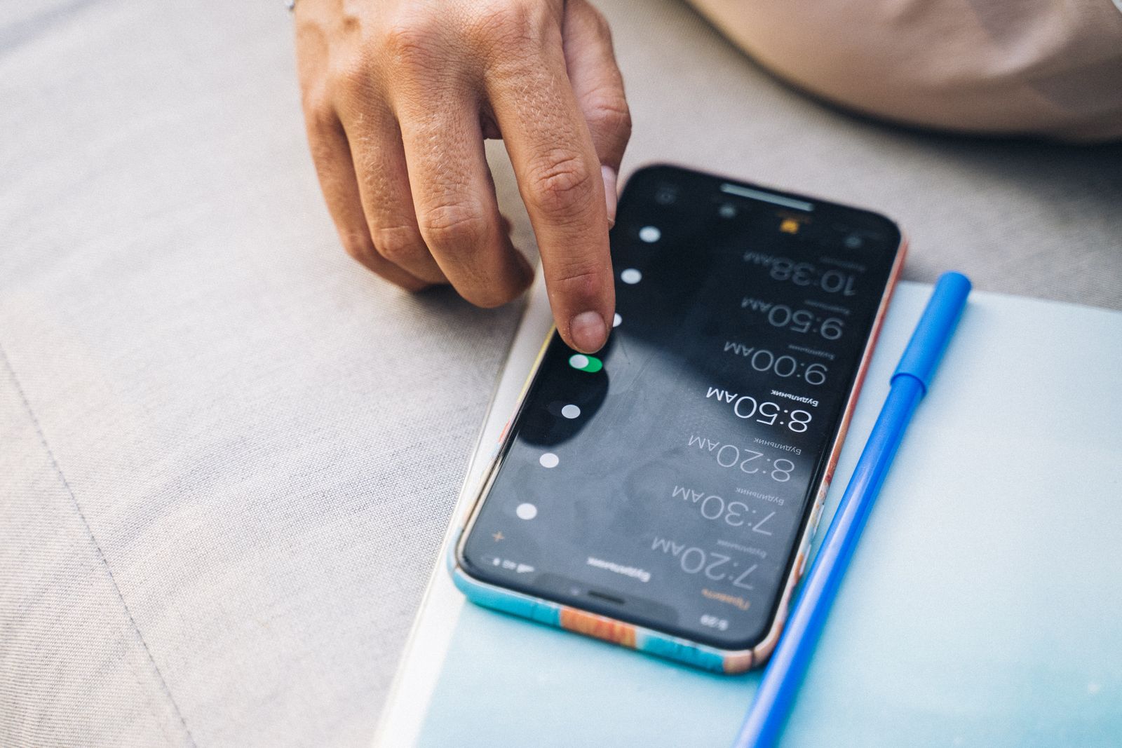 Main touchant l'écran tactile d'un smartphone, geste typique d'interaction avec un configurateur 3D sur mobile